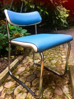 Chaise dans l’esprit Pullman, style administration, structure chromée en forme de traîneau, assise et dossier en skai bleu et blanc. Dimensions: H 65, L 45, P 45, H assise 45.