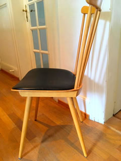 Chaise estampillée Baumann, en bois, galette en skai noir, dossier à barreaux, très confortable, dimensions : H 86, H assise 45, l 42 cm.