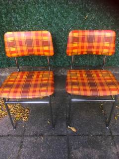 Duo de chaises, chaises de cuisine des années 60/70, entièrement d’origine, structure en métal chromé, assise et dossier confortables, recouverts de skai, motifs à carreaux, couleur dominante orange, la mousse ayant gardé sa densité.