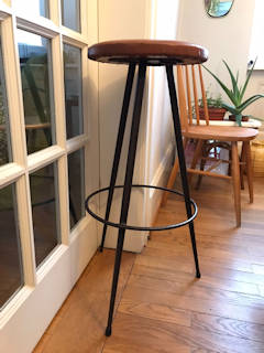Élégant tabouret de bar, assise ronde au revêtement d’origine Skaï couleur cuir, piétement trépied en métal, dans son jus, dimensions : diamètre assise 33 cm, diamètre repose-pied 36 cm, H 75 cm.