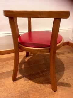 Siège Baumann en bois, assise recouverte de Skaï rouge, hauteur assise 24cm, hauteur dossier 38cm.