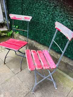 Paire de chaises anciennes de jardin, pliantes, structure métal, assise et dossier en lattes de bois, peinture rouge d’origine écaillée, dans leur jus.