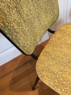 Paire de chaises jaunes, dans leur jus, structure métal noir, pieds fuseaux, revêtement Skaï jaune moucheté noir.