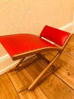 Repose-pieds à bascule ancien, structure bois, revêtement en similicuir rouge, pliable, réglable en hauteur, dimensions : L 65 cm, P 34 cm.