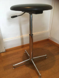 Tabouret réglable KOR 70’, assise en Skaï noir d’origine, diamètre 33 cm, piétement en acier chromé, système de réglage fonctionnel, H mini 43, H maxi 70.