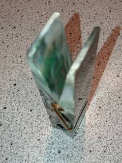 Pince à courrier, ou document, presse papier en plastique, couleurs marbrées à dominante vert, dimensions : L 15 cm, H 3 cm, l 3,5 cm.