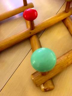 Portemanteau accordéon en bois, se déplie à volonté, 7 pommeaux de couleur vive en plastique, 2 accroches métal pour fixation murale, excellent état.