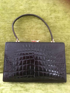 Sac à main en cuir véritable, avec fermeture par encliquetage, intérieur doublé cuir, deux compartiments latéraux, dont un avec fermeture à clipser et deux poches, dimensions : L 29,5, H 29, P 8.