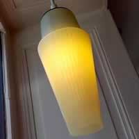 Opaline en forme de fuseau jaune pastel avec rayures.