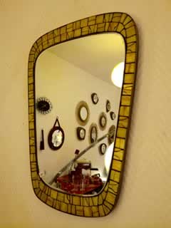 Miroir à bordure en céramique, forme libre, dim: H 45 cm; l 31 cm.