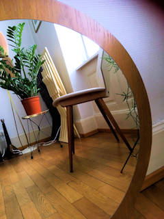 Miroir de style scandinave, de forme ronde, support bois et placage acajou, diamètre du miroir 55 cm, diamètre de l’ensemble 65 cm.
