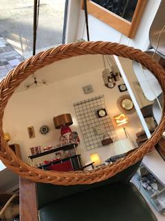 Miroir oval à bordure en osier tressé, dimensions : L 59 cm, H 42 cm.