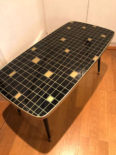 Bout de canapé ou table basse, plateau en verre sérigraphié avec motifs géométriques dorés sur fond noir, garni d’un champ doré avec liseré noir, sur 4 pieds compas en bois  et embouts laiton; dimensions : L 90 cm, l 45,5 cm, H 46 cm.