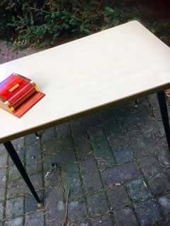 Table basse, plateau Formica beige, piètement métal fuselé, embouts de pieds rotules laiton, H 53cm, L 72cm, l 46cm.