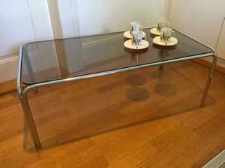 Pieds inox, verre fumé, dimensions: longueur 93cm, largeur 48cm, hauteur 33,5cm.
