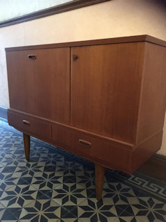 Meuble bar, années 60, design scandinave, deux tiroirs, porte bar basculante, en plus d’un deuxième compartiment de rangement. Dimensions : L 110, P 38, H 85.