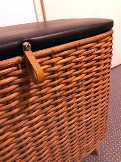 Panier à linge ou coffre à jouets, en rotin, couvercle tapissé en Skaï noir d’origine, deux poignées latérales, peut sévir comme assise d’appoint, dimensions : L 62 cm, P 40 cm, H 42 cm.