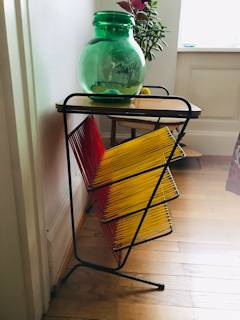 Petite table d’appoint, ou bout de canapé, ou porte revue ou vinyle, plateau en bois, pieds en métal noir, fils de scoubidou rouge et jaune d’origine; dimensions : P 40 cm, L 47 cm, H 61,5 cm.