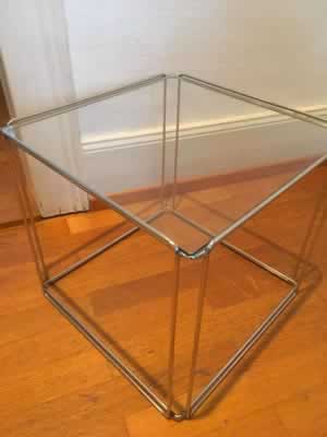 Sellette du designer Max Sauze, années 70, vitre posée sur structure en tiges d’acier chromé, présence d’une petite rayure sur la vitre, dimensions: 39 cm de côté, H 36 cm.