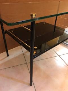 Table basse Pierre Guariche, made in France by Airborne, plateau supérieur en verre transparent, plateau intermédiaire en verre noir, piétement en métal laqué noir intégrant un porte-revue, visserie en laiton, dimensions : L 90 cm, P 45 cm, H 44,5 cm.
