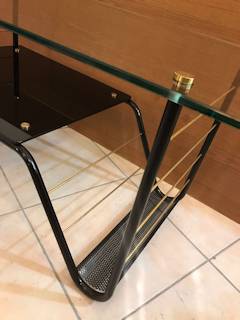 Table basse Pierre Guariche, made in France by Airborne, plateau supérieur en verre transparent, plateau intermédiaire en verre noir, piétement en métal laqué noir intégrant un porte-revue, visserie en laiton, dimensions : L 90 cm, P 45 cm, H 44,5 cm.