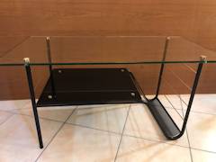 Table basse Pierre Guariche, made in France by Airborne, plateau supérieur en verre transparent, plateau intermédiaire en verre noir, piétement en métal laqué noir intégrant un porte-revue, visserie en laiton, dimensions : L 90 cm, P 45 cm, H 44,5 cm.