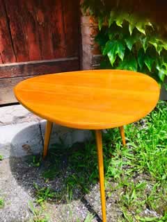 Table basse tripode, plateau triangulaire, en placage de bois blond, liseré marqueté, pieds compas, H 55, L 71cm.
