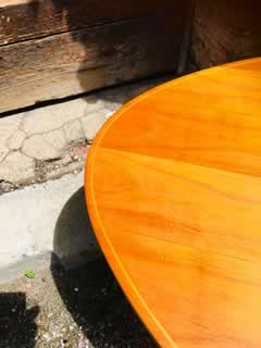 Table basse tripode, plateau triangulaire, en placage de bois blond, liseré marqueté, pieds compas, H 55, L 71cm.