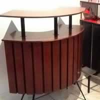 Meuble bar en bois plaqué vernis avec plateau surélevé, piétement métal noir.