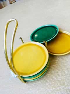 Ensemble vintage de 6 dessous de verre en faïence avec son support métal jaune, 3 de couleur jaune et 3 de couleur verte. Très bon état.