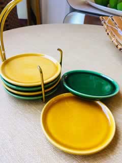 Ensemble vintage de 6 dessous de verre en faïence avec son support métal jaune, 3 de couleur jaune et 3 de couleur verte. Très bon état.