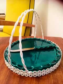 Plateau à fromage en céramique des années 50, signé Yvon Roy, avec son support en métal perforé à double anse torsadée, dans le style de Mathieu Matégot, présence de son couteau, diamètre 23,5cm, H 18,5cm.