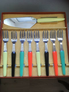 Service à dessert vintage, 8 fourchettes et une pelle à tarte, inox et manche en plastique.